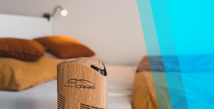 Detail čističky vzduchu Ionic-CARE v dekore dubového dreva, posteľ v pozadí