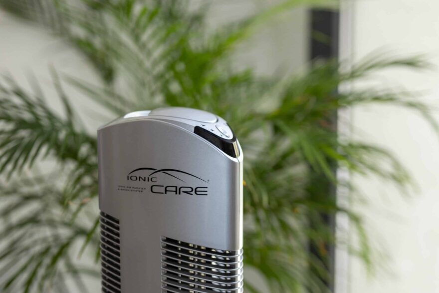 Detail čističky vzduchu Ionic-CARE ve stříbrné barvě, v pozadí se zelenou rostlinou